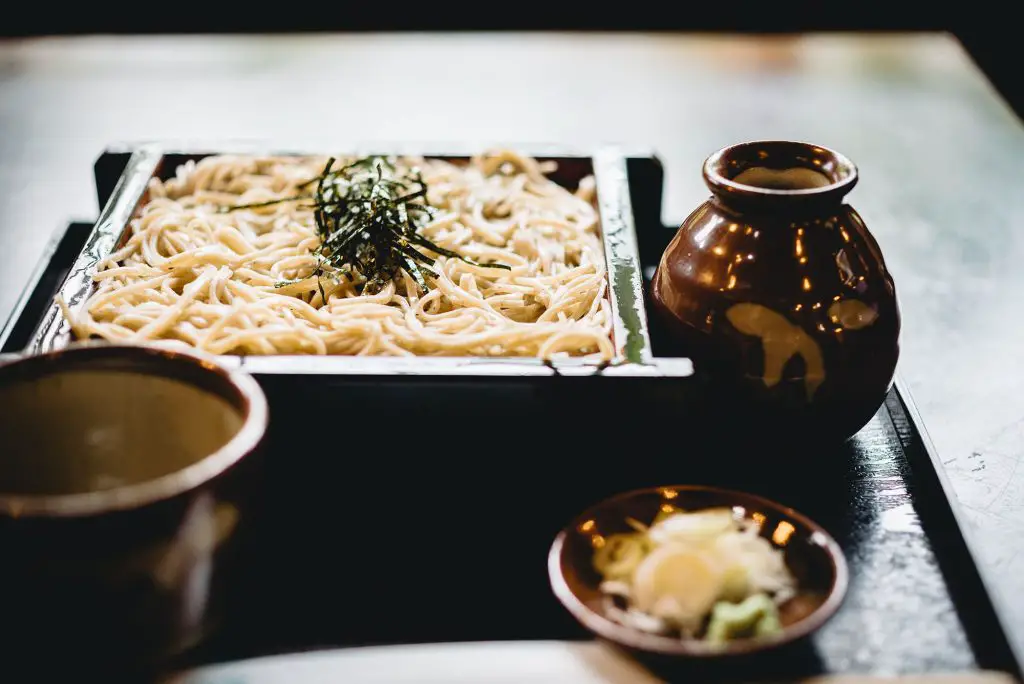 Ett fat med japanska nudlar av typen soba med tillbehör som grönsaker och soppa-