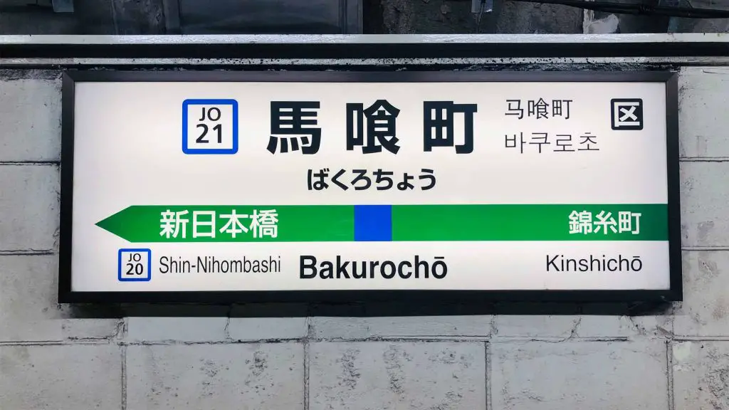 Skylt på en tågstation med information på flera språk.